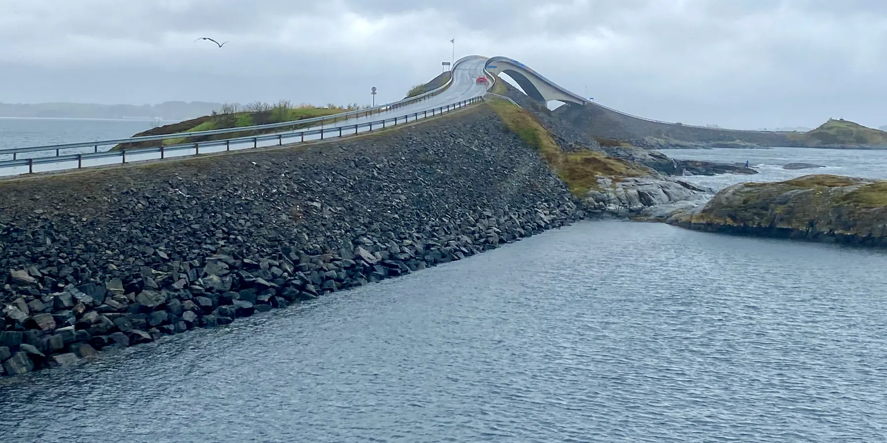 Una carretera sobre el mar que une islotes bajo un cielo nublado.