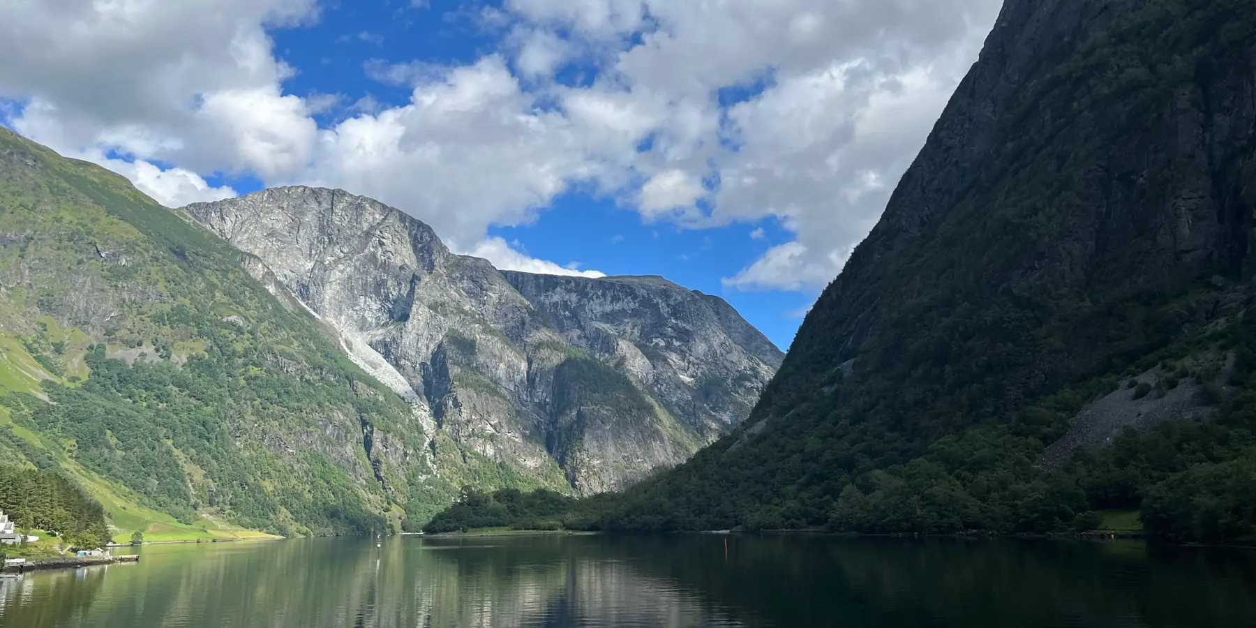 Un fiordo entre montañas, con el agua en calma.